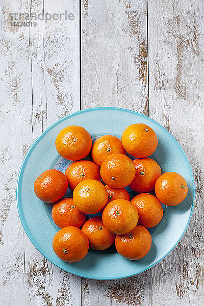 Mandarinen auf blauer Platte auf Holzgrund