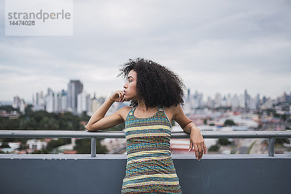 Panama  Panama City  nachdenkliche junge Frau auf dem Balkon  die in die Ferne schaut