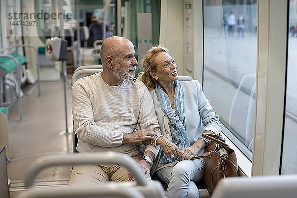 Älteres Ehepaar sitzt in einer Straßenbahn