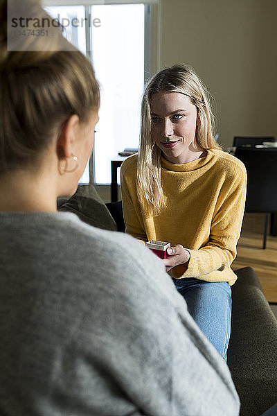 Lesbische Frau macht ihrer Freundin einen Heiratsantrag  in der Schachtel mit dem Verlobungsring