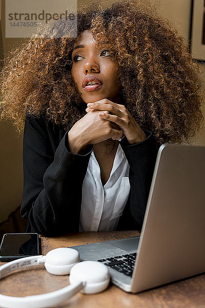 Junge Frau mit Laptop in einem Cafe