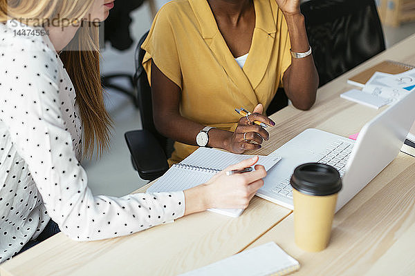 Kollegen arbeiten zusammen am Schreibtisch im Büro