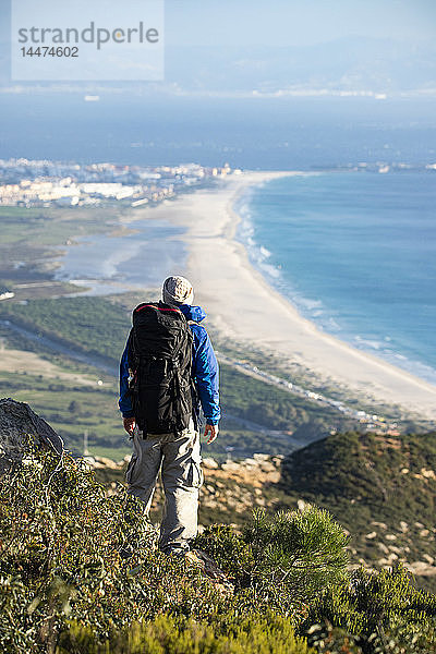 Spanien  Andalusien  Tarifa  Mann auf einer Wanderung an der Küste mit Blick auf die Aussicht
