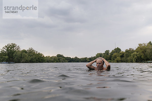 Älterer Mann schwimmt in einem See