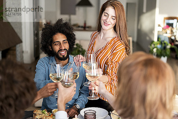 Freunde trinken Wein bei einer Dinnerparty  klirrende Gläser