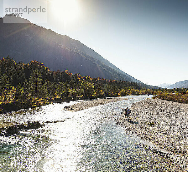 Österreich  Alpen  Ehepaar auf Wanderung an einem Bach stehend