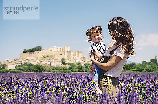 Frankreich  Grignan  Porträt eines glücklichen Mädchens zusammen mit ihrer Mutter im Lavendelfeld