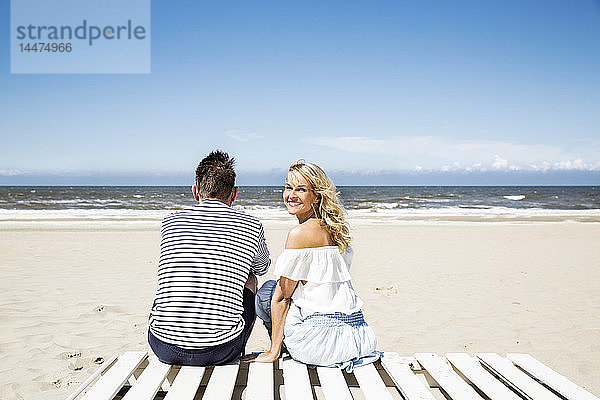 Ehepaar sitzt auf der Strandpromenade