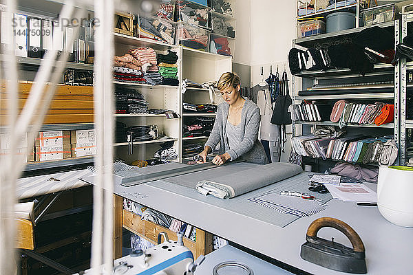 Modedesignerin  die im Atelier an einer Vorlage arbeitet