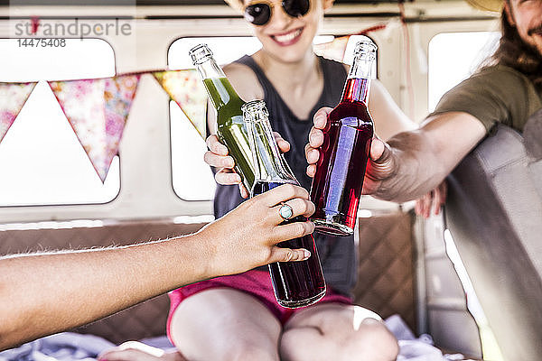 Glückliche Freunde in klirrenden Flaschen im Lieferwagen
