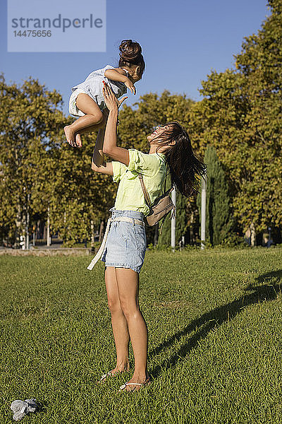 Glückliche Mutter spielt mit Tochter im Park