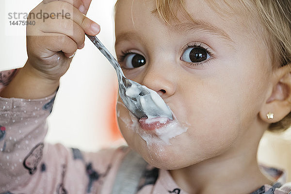 Porträt eines kleinen Mädchens  das Joghurt isst  Nahaufnahme
