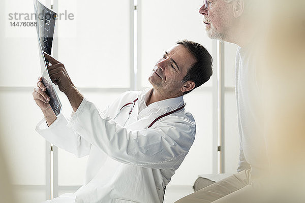 Arzt bespricht MRT-Bild mit Patient in medizinischer Praxis