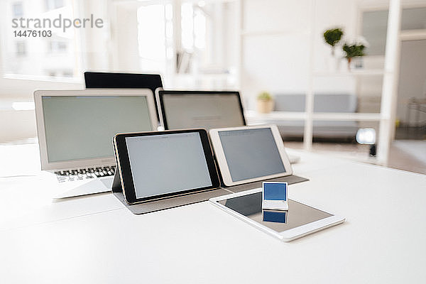 Miniatur-Laptop und mobile Geräte auf einem Schreibtisch