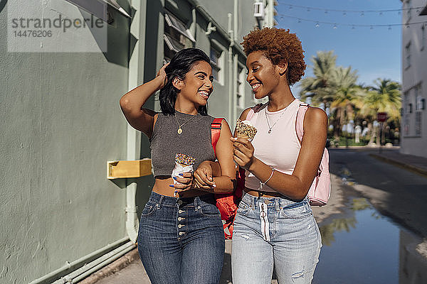USA  Florida  Miami Beach  zwei glückliche Freundinnen mit Eistüten in der Stadt