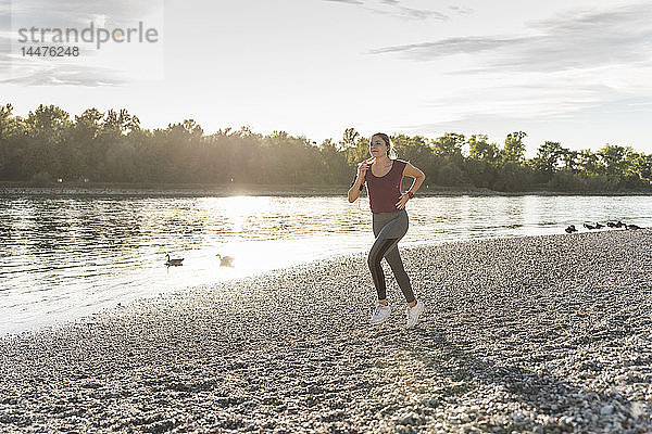 Junge Frau joggt am Fluss