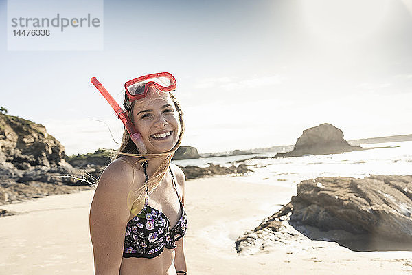 Glückliche junge Frau mit Schnorchelausrüstung am Strand  Porträt
