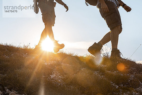 Italien  Monte Nerone  Nahaufnahme von zwei Männern  die bei Sonnenuntergang in den Bergen wandern