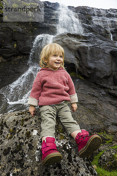 Dänemark  Färöer-Inseln  Estuyroy  Kleinkind vor einem Wasserfall