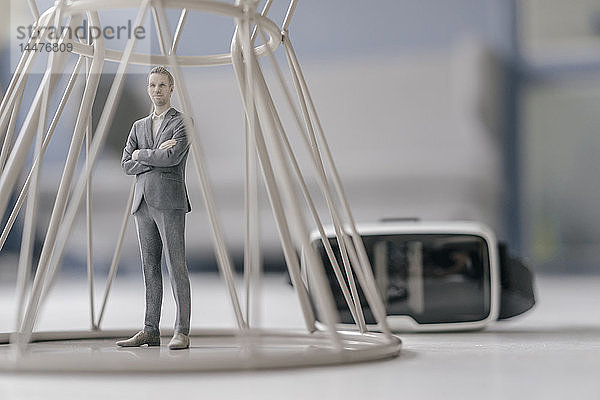 Miniatur-Geschäftsmann-Figur  die innerhalb der Struktur bis hin zu VR-Gläsern steht