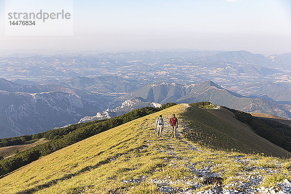 Italien  Monte Nerone  zwei Männer wandern im Sommer auf einen Berg