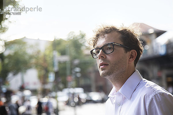 Deutschland  Berlin  Porträt eines Geschäftsmannes mit Stoppeln und Brille auf der Straße