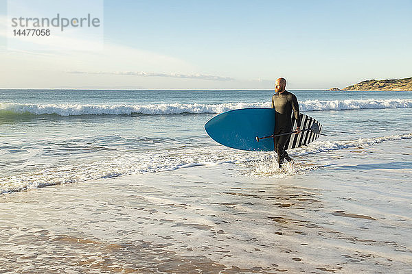 Spanien  Andalusien  Tarifa  Mann mit aufrechtem Paddelbrett am Meer