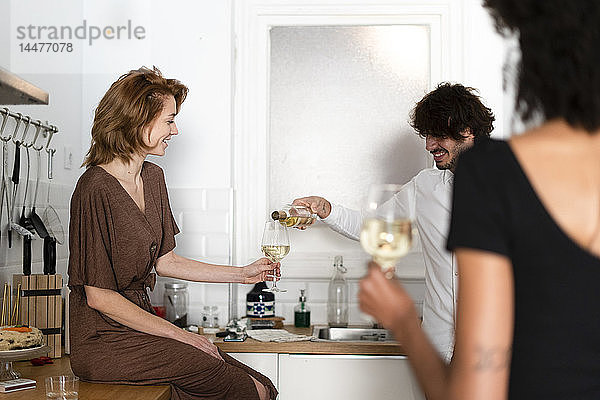 Freunde amüsieren sich auf einer Party  trinken Wein in der Küche