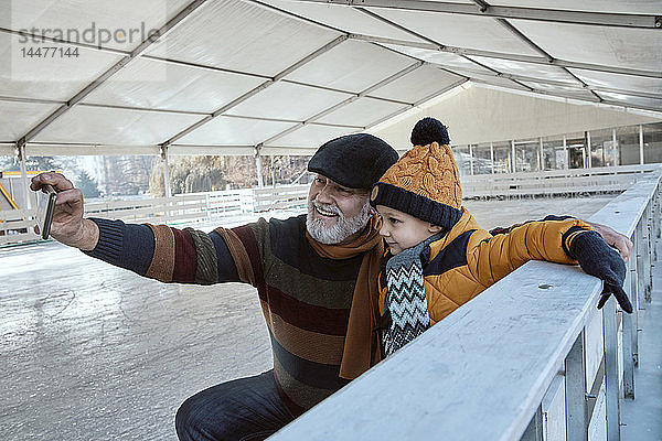 Grossvater und Enkel auf der Eisbahn  sich selbst nehmen