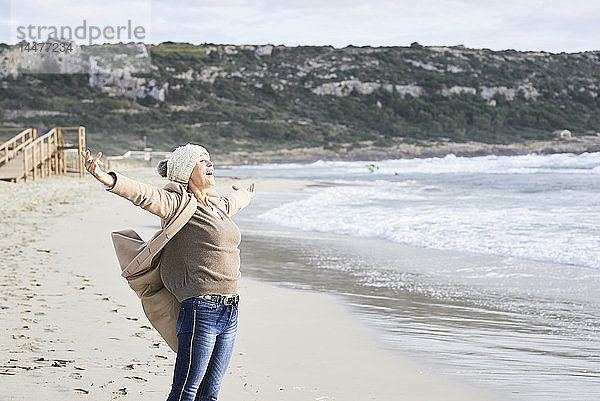 Spanien  Menorca  glücklicher älterer Mann  der im Winter an der Meeresküste steht