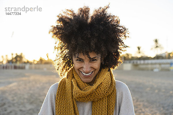 Porträt einer glücklichen Frau am Strand  die ein gelbes Halstuch trägt