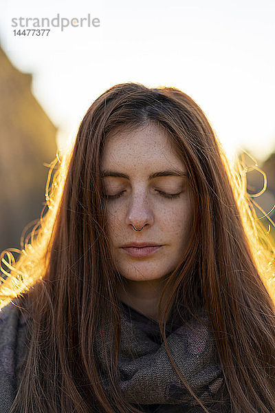 Porträt einer sommersprossigen jungen Frau mit Nasenpiercing im Herbst