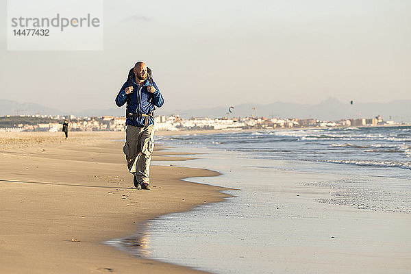 Spanien  Andalusien  Tarifa  Mann beim Wandern am Strand