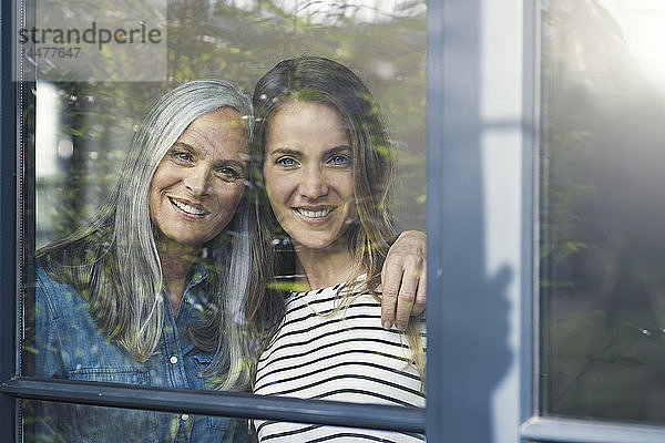 Mutter und Tochter schauen aus dem Fenster