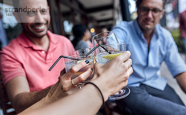 Eine Gruppe von Freunden amüsiert sich und stößt auf einer Terrasse an