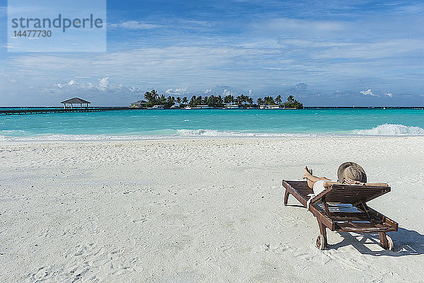 Malediven  Ari Atoll  Nalaguraidhoo  Sun Island Resort  Rückenansicht einer Frau  die sich am Strand entspannt