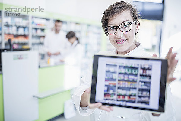 Porträt eines lächelnden Apothekers in der Apotheke mit Tablette