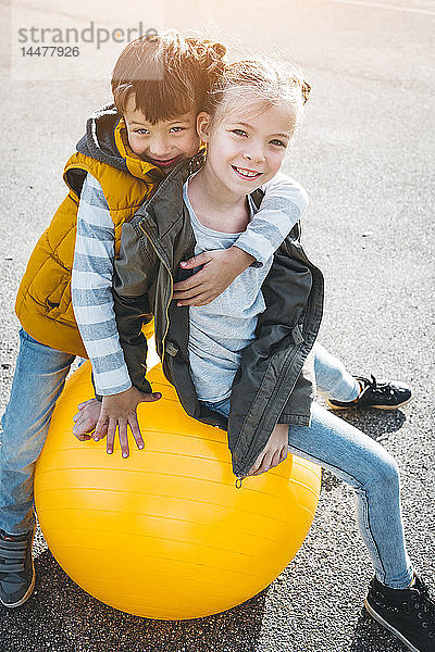 Porträt von zwei Kindern  die sich mit dem Gymnastikball amüsieren