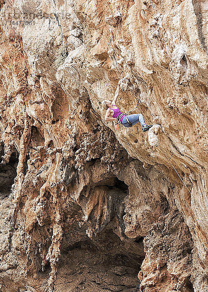 Griechenland  Kalymnos  Frau klettert in Felswand