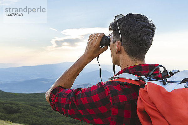 Italien  Monte Nerone  Wanderer in den Bergen  der mit dem Fernglas schaut