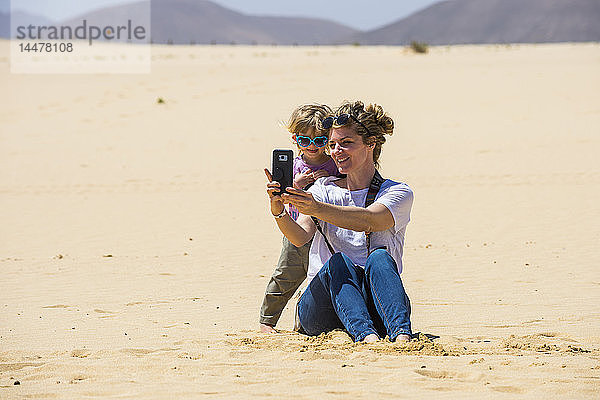 Spanien  Kanarische Inseln  Fuerteventura  Parque Natural de Corralejo  Mutter und Tochter beim Selfie in den Sanddünen