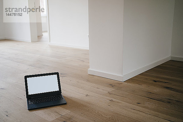 Laptop auf Holzboden in einem neu renovierten Haus
