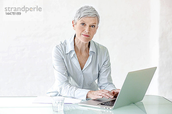 Porträt einer reifen Geschäftsfrau  die am Laptop arbeitet