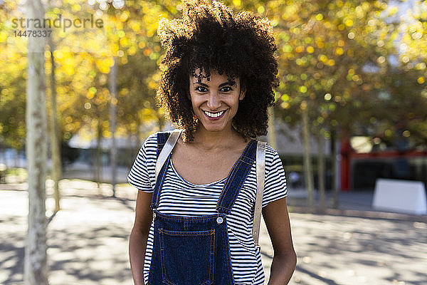 Porträt einer lächelnden Frau  stehend in einem Park