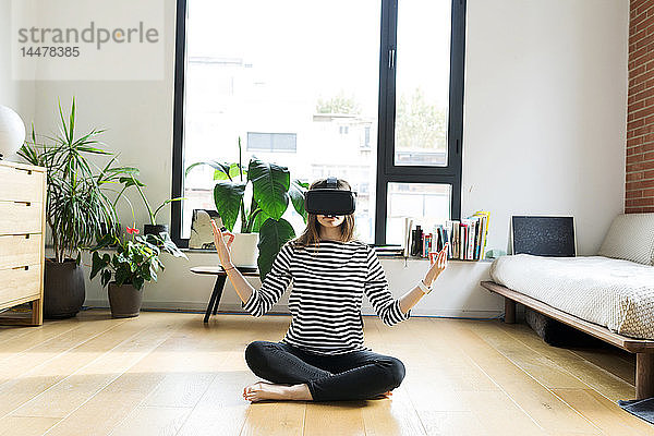 Junge Frau zu Hause mit VR-Brille beim Yoga