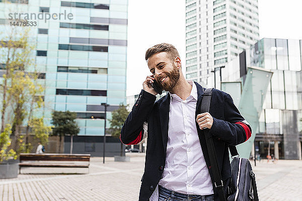 Stilvoller Geschäftsmann telefoniert in der Stadt mit dem Handy