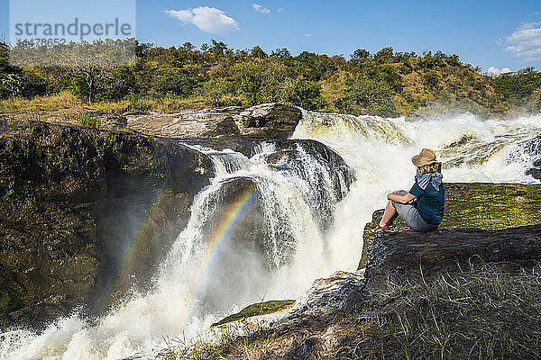Afrika  Uganda  Frau blickt auf die atemberaubenden Murchison Falls  am Nil  Murchison Falls National Park