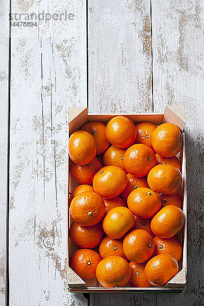 Mandarinen in Kiste  auf weißem  hölzernem Hintergrund