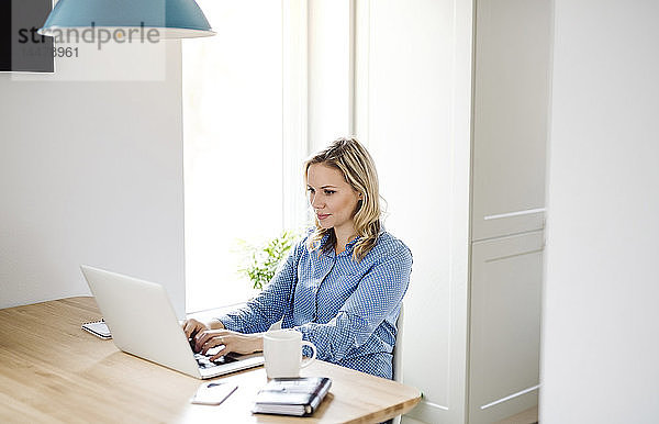 Frau mit Laptop bei der Arbeit zu Hause