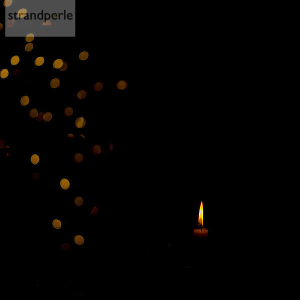 Brennende Kerze in der Dunkelheit